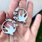 Detalle de aros golondrinas calados a mano en plata