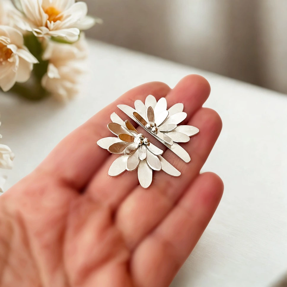 Aros mitad flor creados en plata con detalle delicado