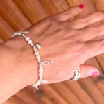 Detalle de pulsera con perlas y dijes únicos