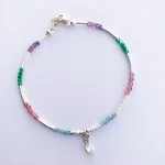 Accesorio vibrante con cristales y mostacillas de plata