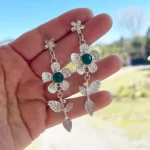 Aros largos de plata con diseño floral y piedra verde