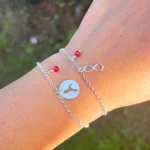 Diseño artesanal en plata con coral rojo y símbolos protectores
