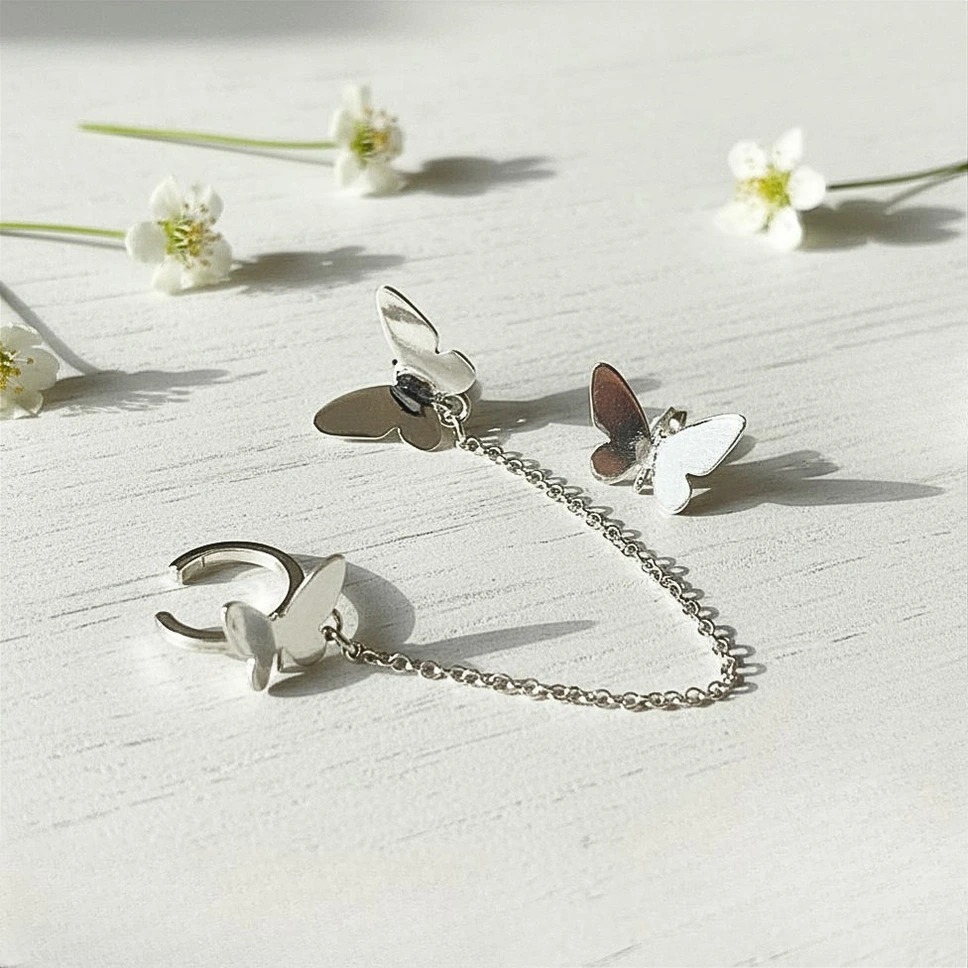 Aros ear cuff de plata con mariposa y cadena delicada