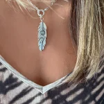 Colgante pluma calado a mano en plata con piedra natural