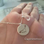 Joya de plata con medalla de constelación y piedra azul