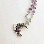 Joya artesanal con mariposa y flores en diseño lunar