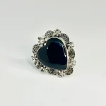 Anillo de corazón oscuro rodeado de flores y hojas