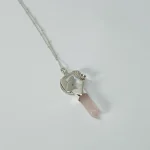 Joya artesanal con punta de cuarzo rosa y diseño de corazones