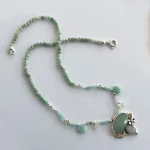 Colgante de plata con colibríes y piedras naturales en tonos menta
