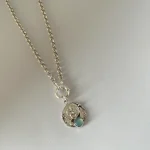 Colgante de plata con querubines y colibrí tallado