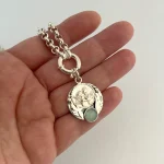 Colgante de querubines con alas caladas y piedra natural