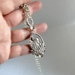 Joya religiosa de plata con piedra y reverso tradicional de Lourdes