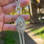 Medalla Virgen de Lourdes encantada en plata 950 con detalles florales