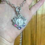 medalla religiosa en plata 950 con decoración botánica