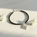 Pulsera artesanal con spinel negro y nudo de bruja en plata