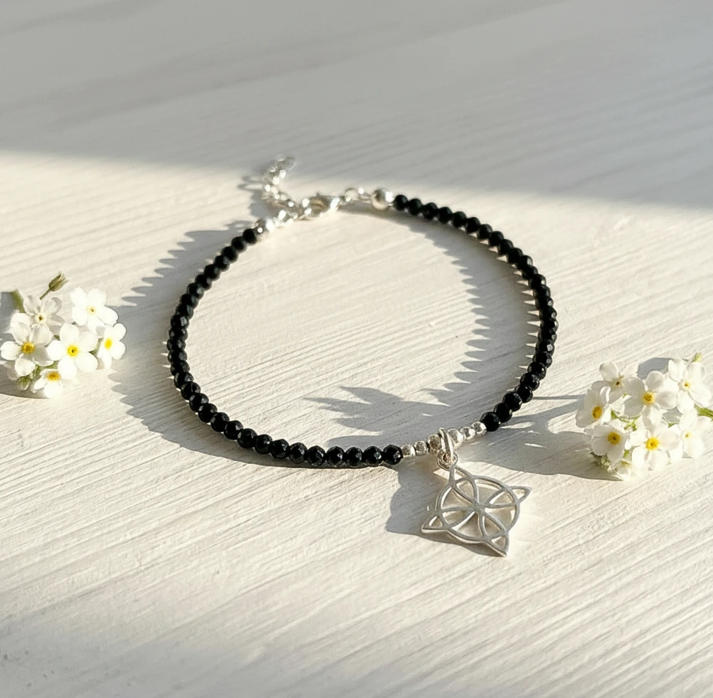 Pulsera artesanal con spinel negro y nudo de bruja en plata