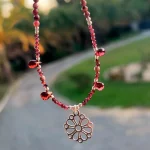 Collar de plata con colgante de mandala calado y piedras granate