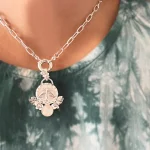Medalla hecha a mano con detalles florales y piedra