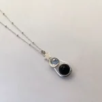 Collar con esfera móvil y detalles de luna y estrellas