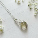 Colgante artesanal de colibrí con cuarzo fumé, flor calada y cristal Swarovski en plata 950 Chile