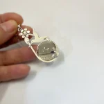 Colgante único con colibrí, esfera giratoria de cuarzo fumé y flor con Swarovski en plata 950