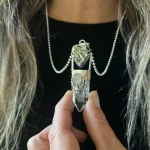 Talismán de prosperidad con pirita natural en corazón de plata 950 y punta de cuarzo cristal