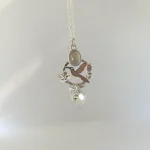 Colgante de autor con colibrí y flores caladas a mano, piedra luna y cuarzo rosa plata 950 Chile
