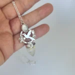 Colgante artesanal único con colibrí, piedra luna y flores caladas a mano en plata 950 Chile