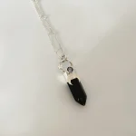 Colgante artesanal con punta de ónix negro, luna martillada y Swarovski en plata 950 - Pilar Segura Orfebre
